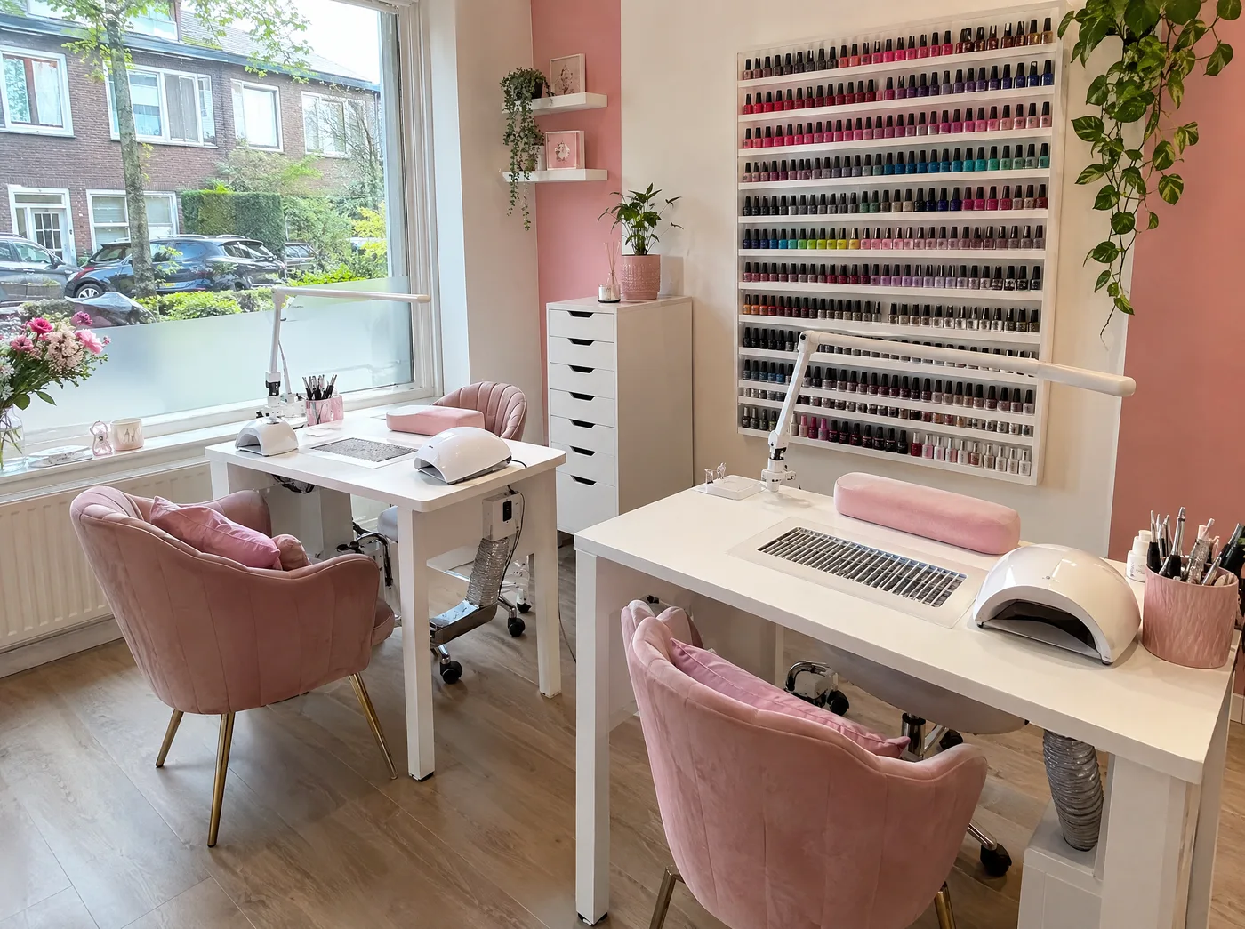 Sfeerbeeld: lichte nagelsalon met manicuretafels en een wand vol lakjes